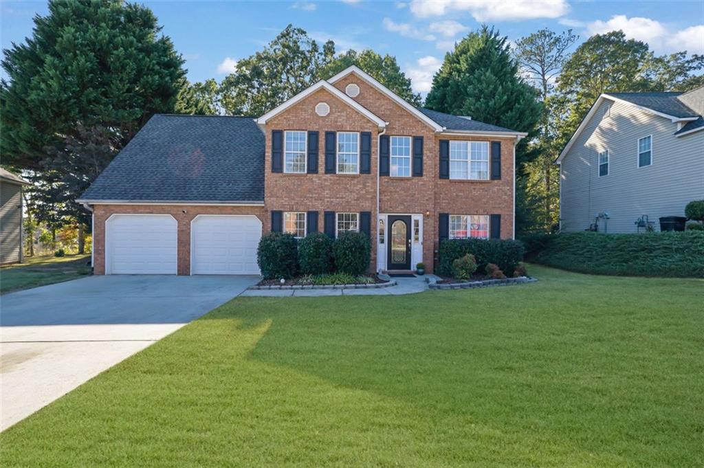 a front view of a house with a yard and garage