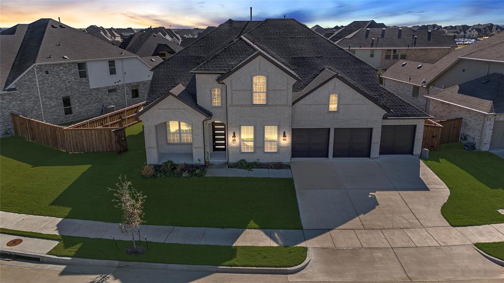 View of front of house featuring a yard and a garage