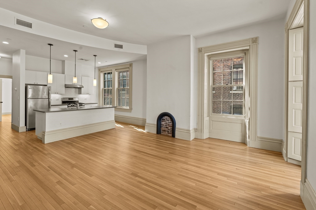 a kitchen with kitchen island a counter top space a sink stainless steel appliances and cabinets