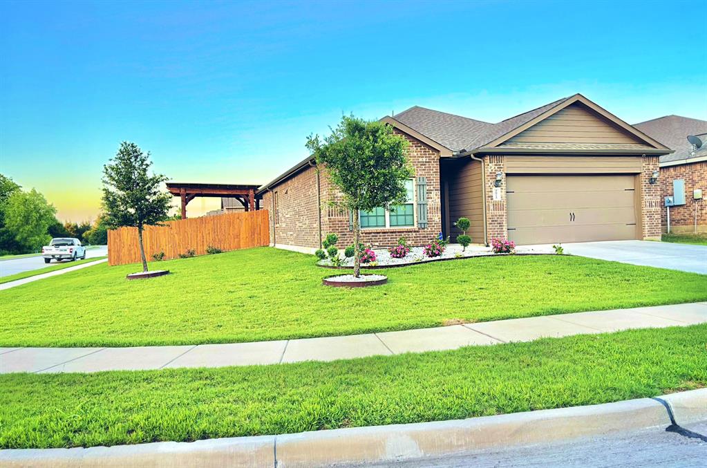 View of front of home featuring a lawn and a garage