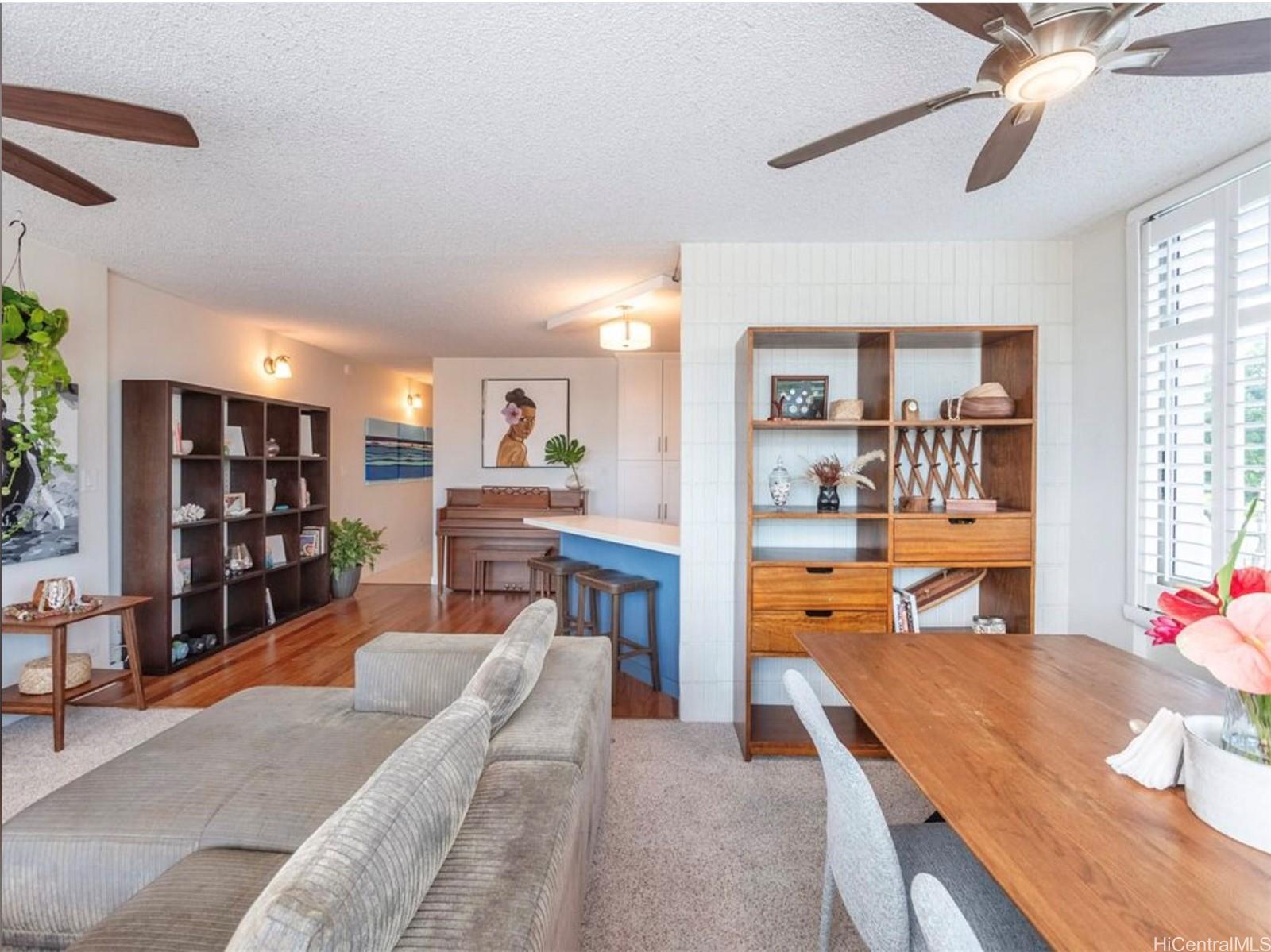 a living room with furniture and a dining table with kitchen view