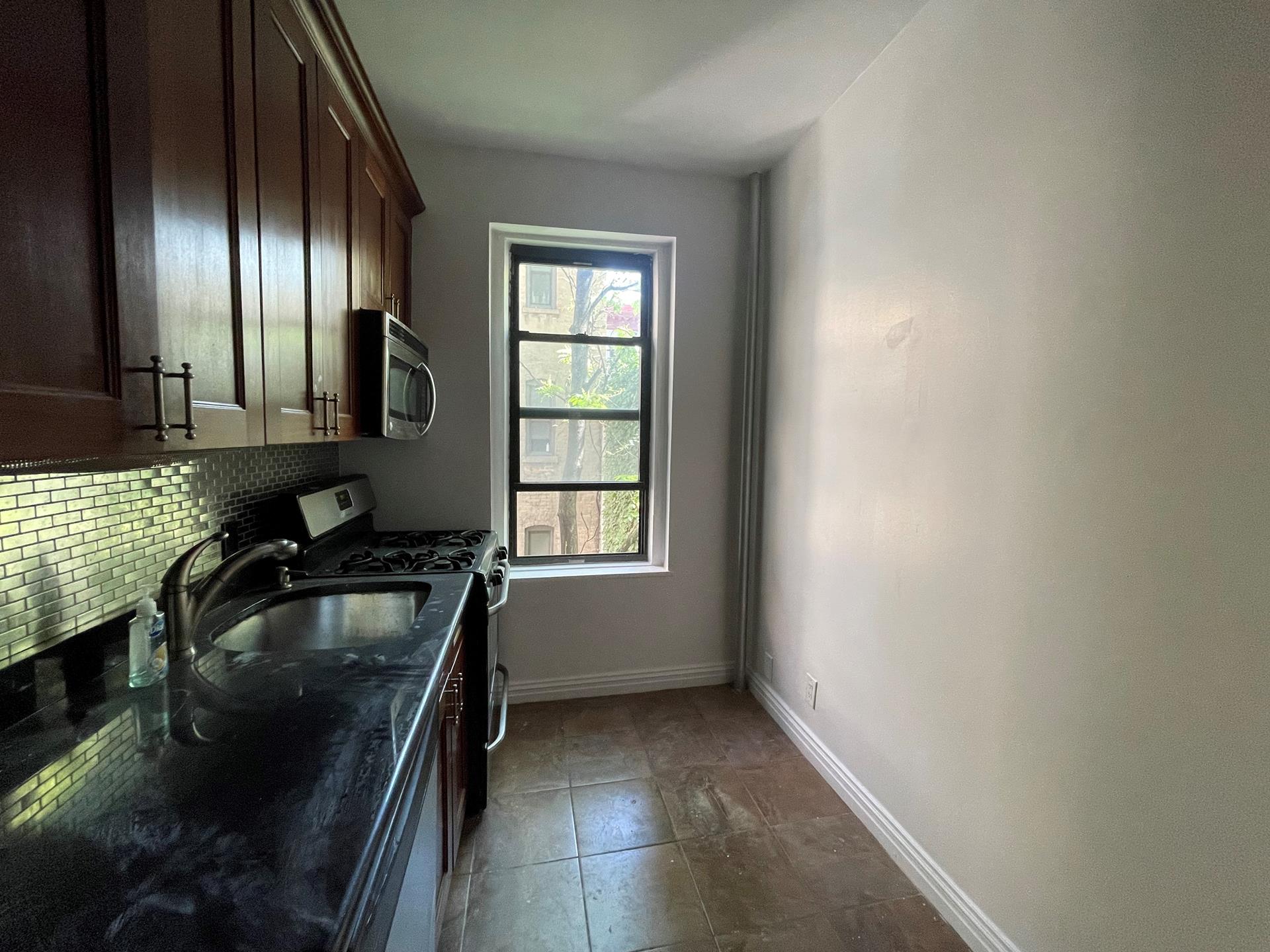 a kitchen with granite countertop stainless steel appliances a sink stove and cabinets