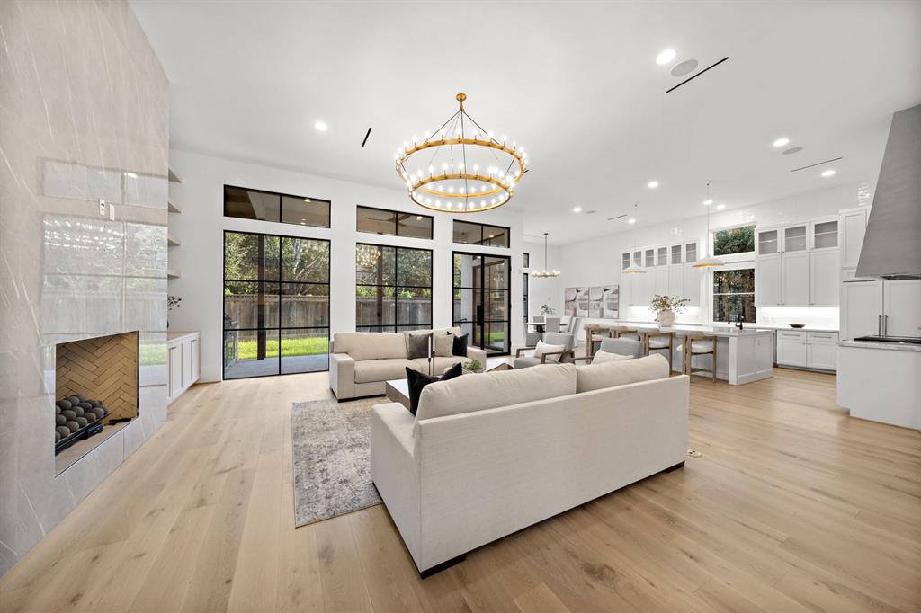 a living room with furniture a fireplace and a dining table with kitchen view