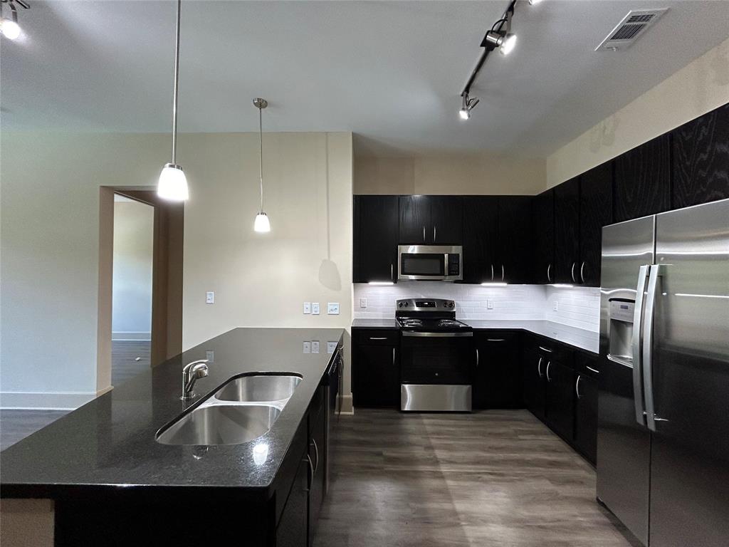 a kitchen with kitchen island a sink appliances and cabinets