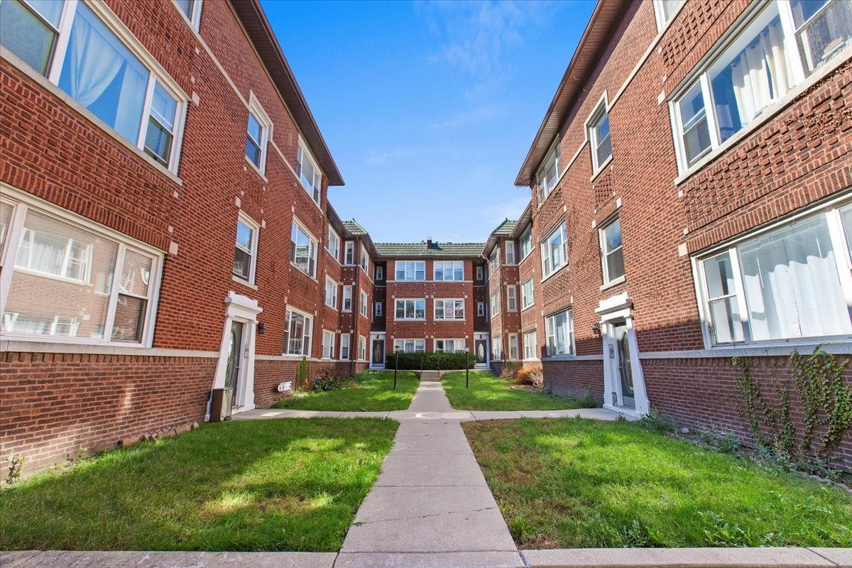 a view of a brick building next to a yard