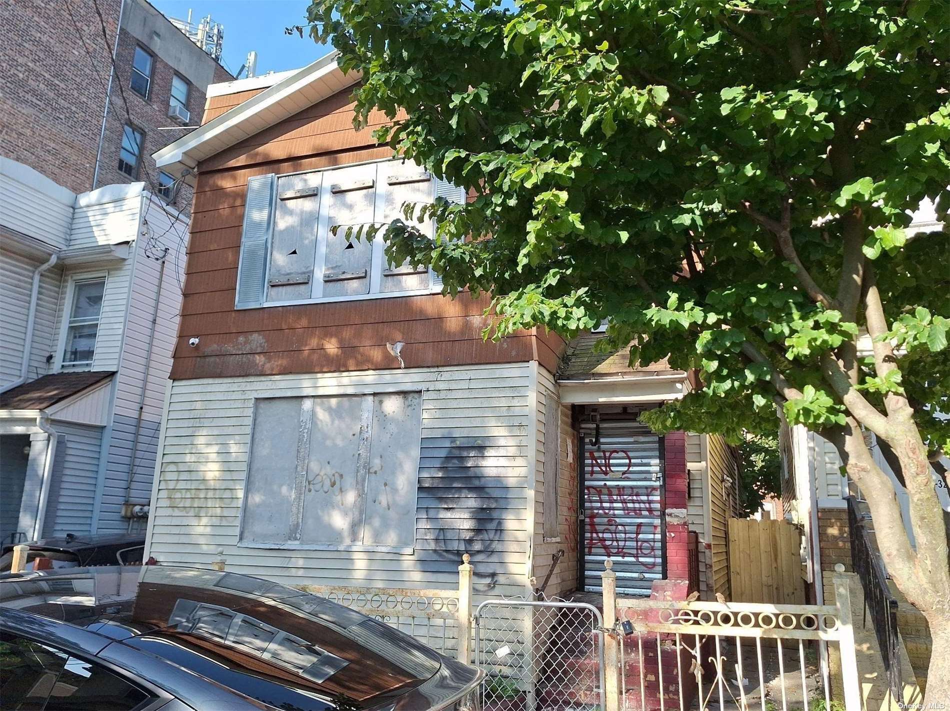 a front view of a house with a tree