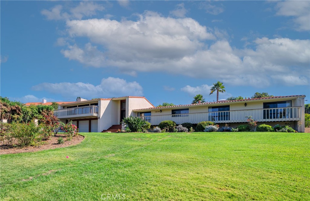 a view of a house with a big yard and potted plants