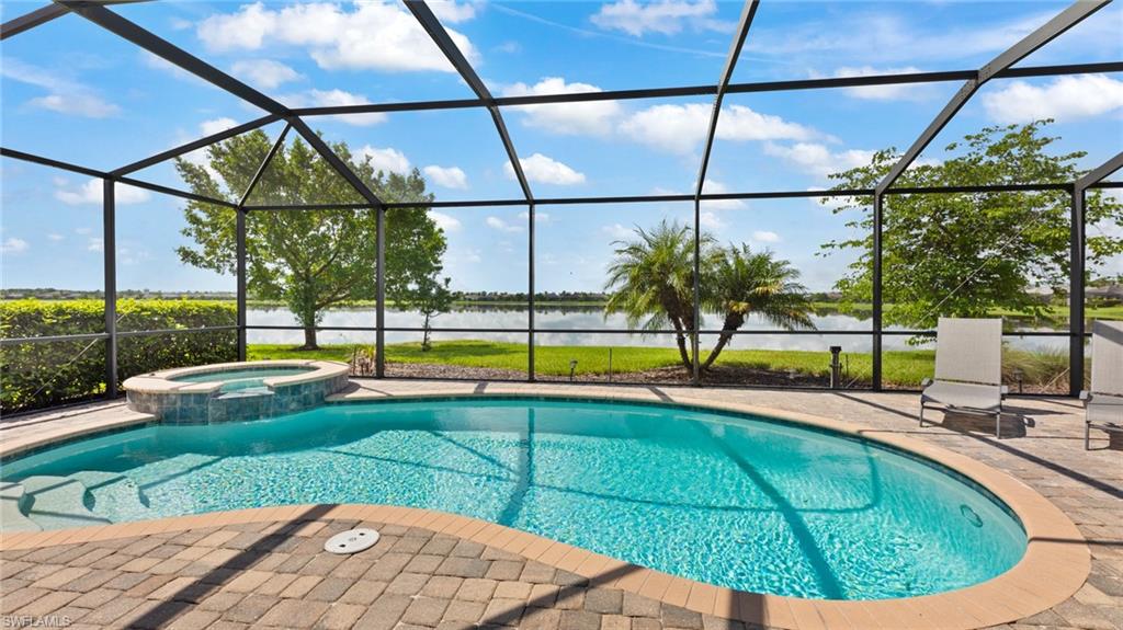 View of pool with an in ground hot tub, a patio area, and a lanai