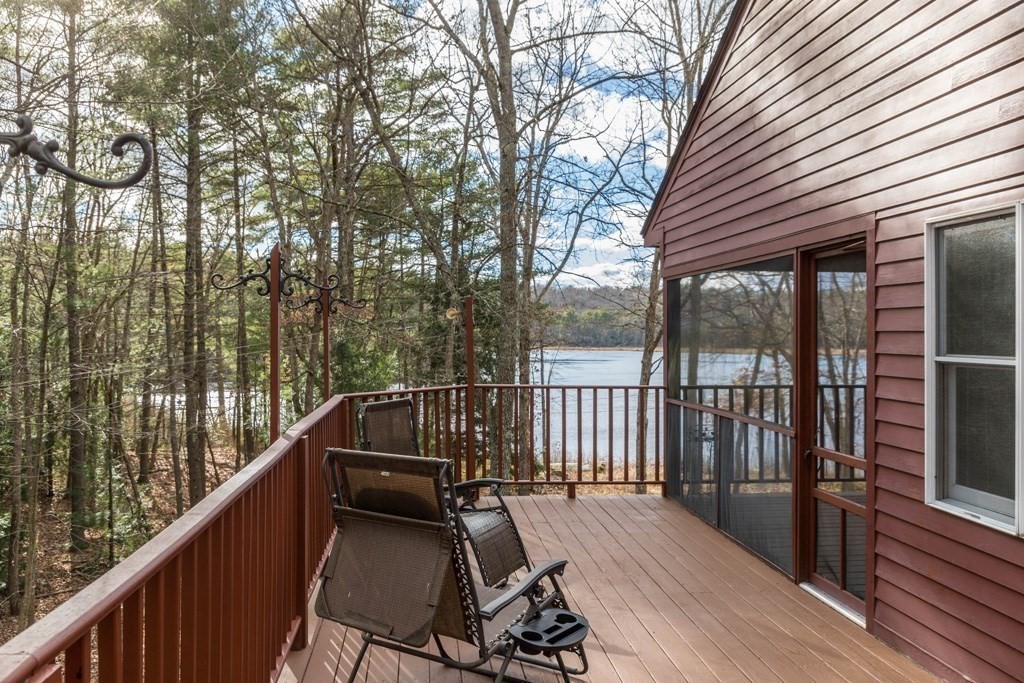 a view of a balcony with chairs and wooden fence