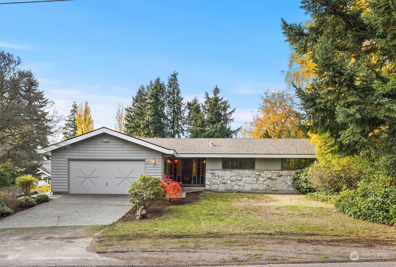 a front view of house with yard and trees in the background