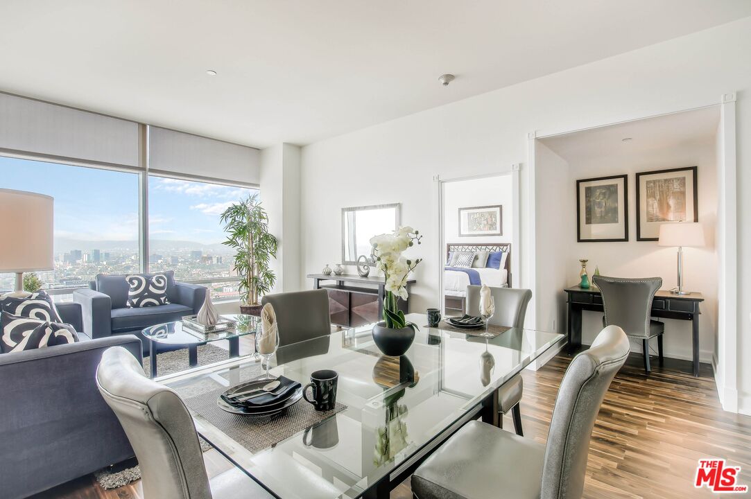 a living room with furniture dining table and a large window