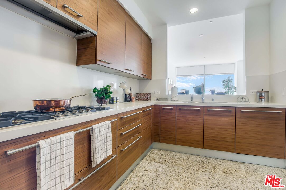 a kitchen with stainless steel appliances granite countertop a sink a stove and cabinets