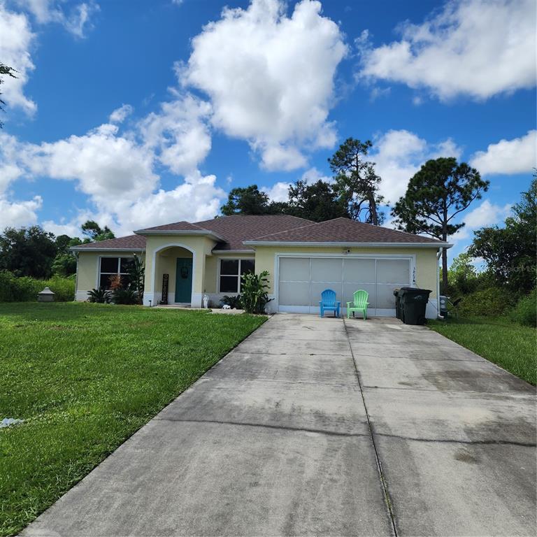 a view of a house with a yard and a garage