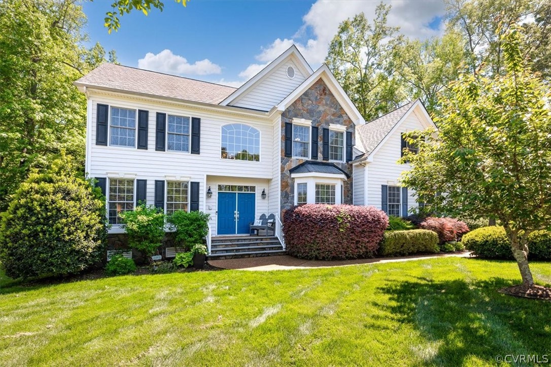 a front view of house with yard and trees in the background