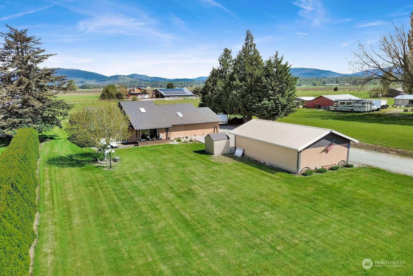 an aerial view of residential house with outdoor space and trees all around