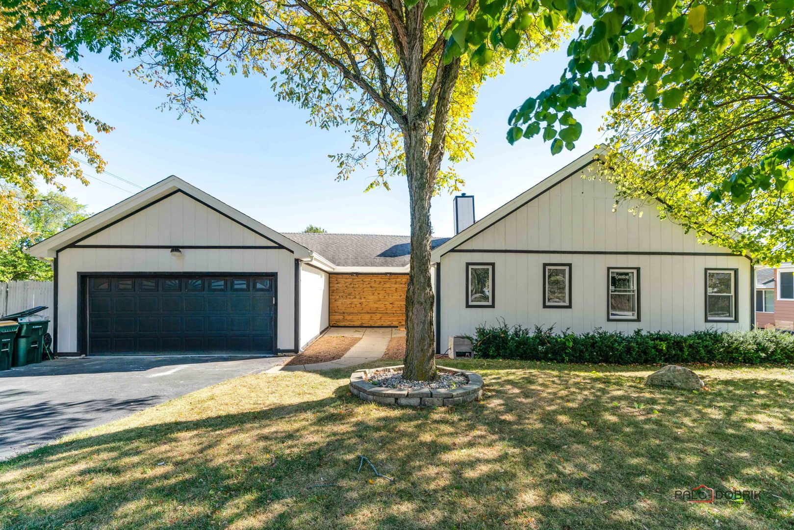 a front view of house with yard and trees around