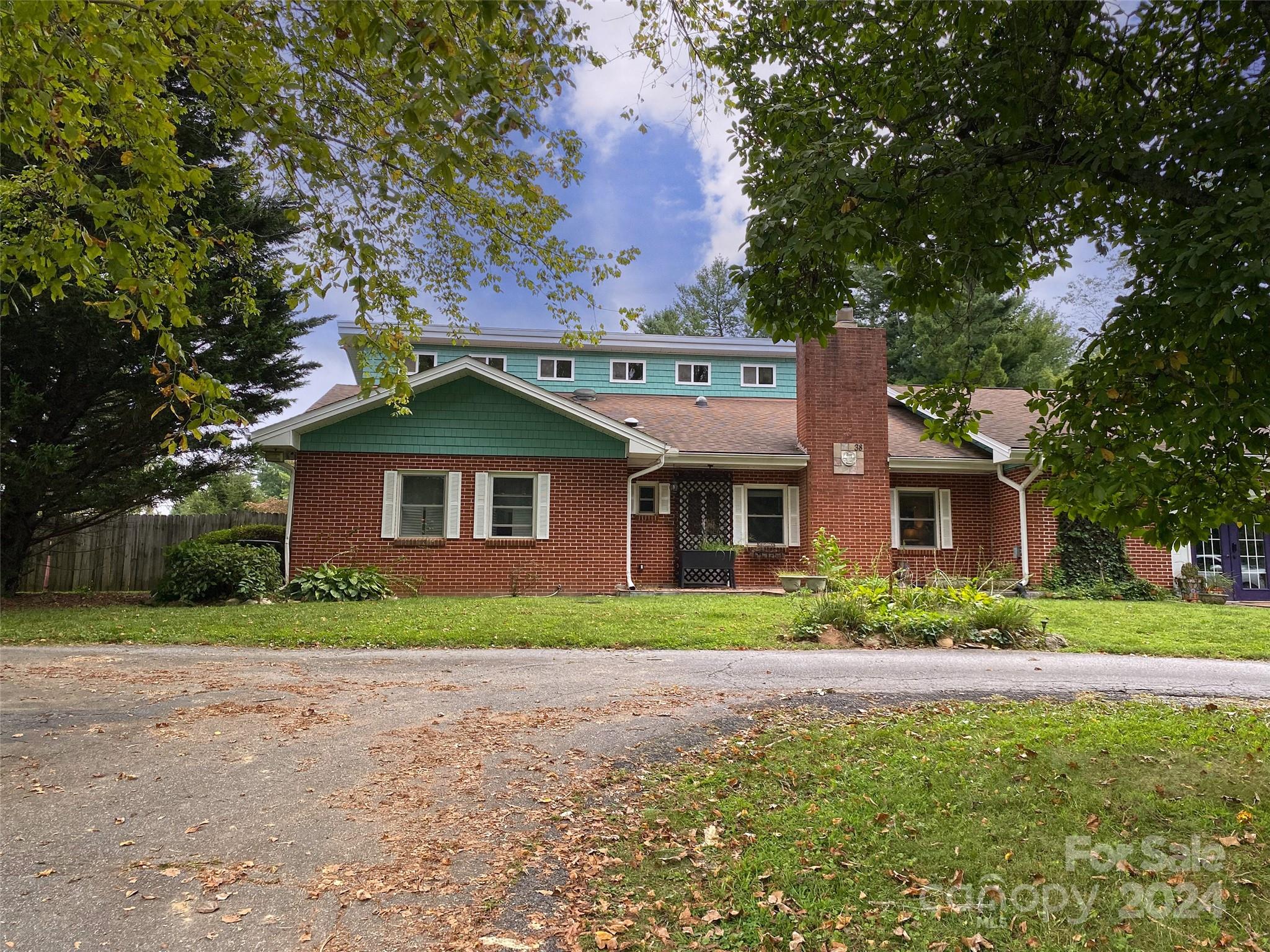 a front view of brick house with a yard