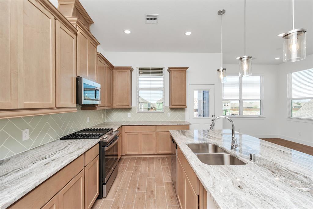 a kitchen with granite countertop a sink stove and cabinets