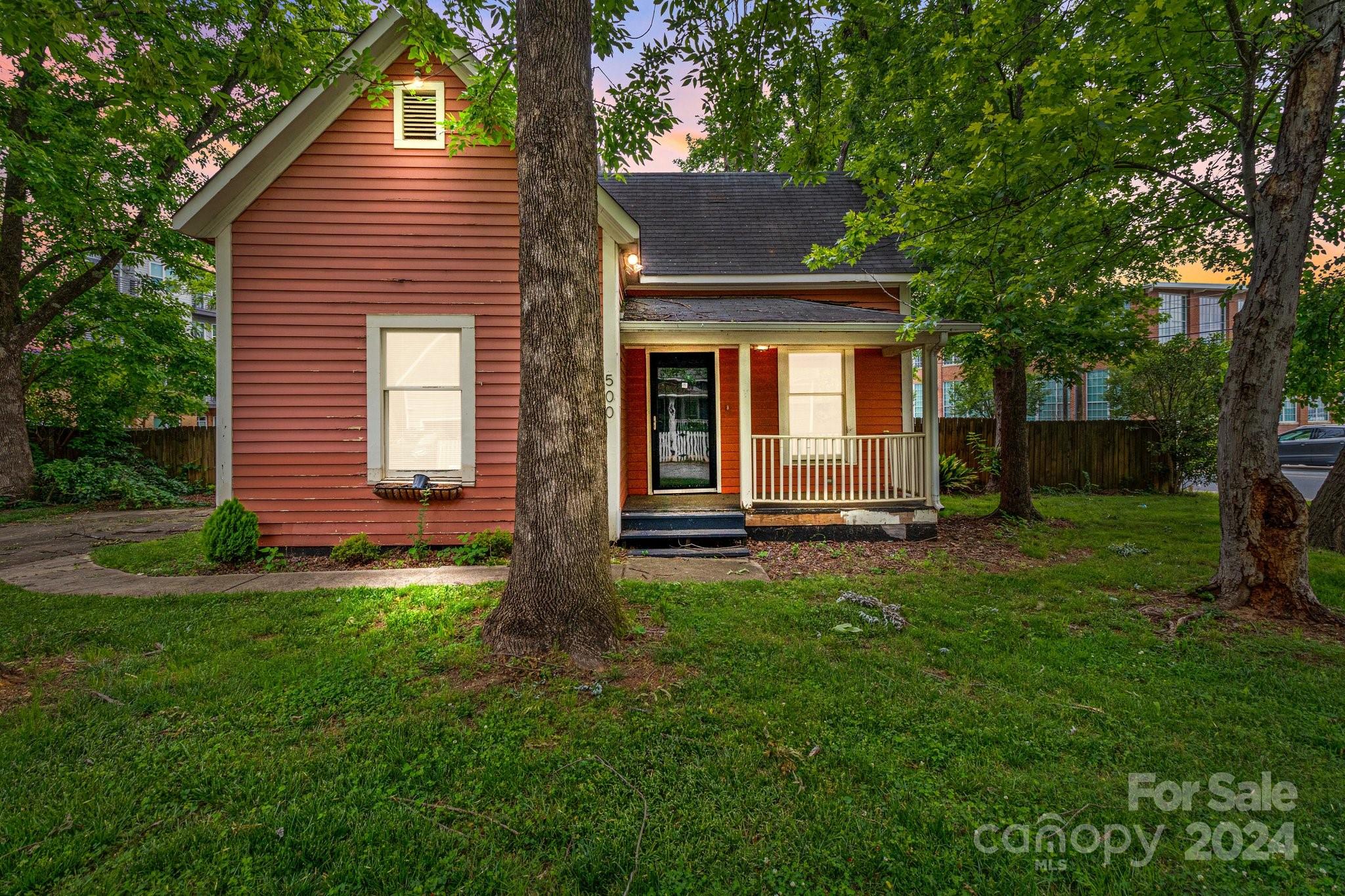 a front view of a house with a yard and trees