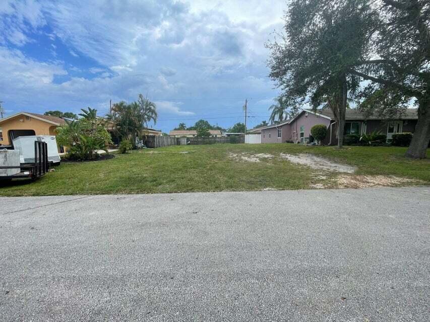 a view of a house with a yard and large trees