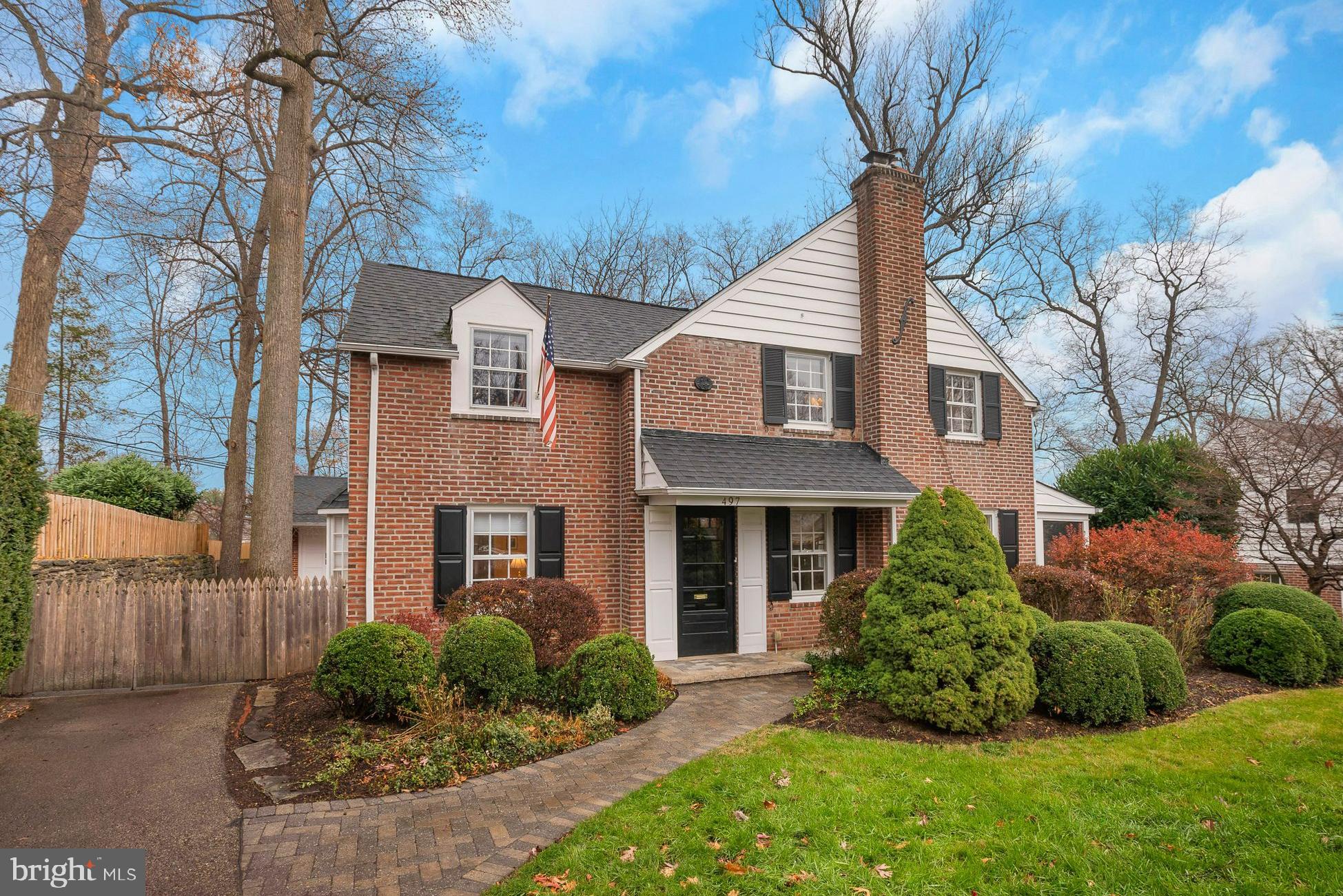 a front view of a house with a yard and potted plants