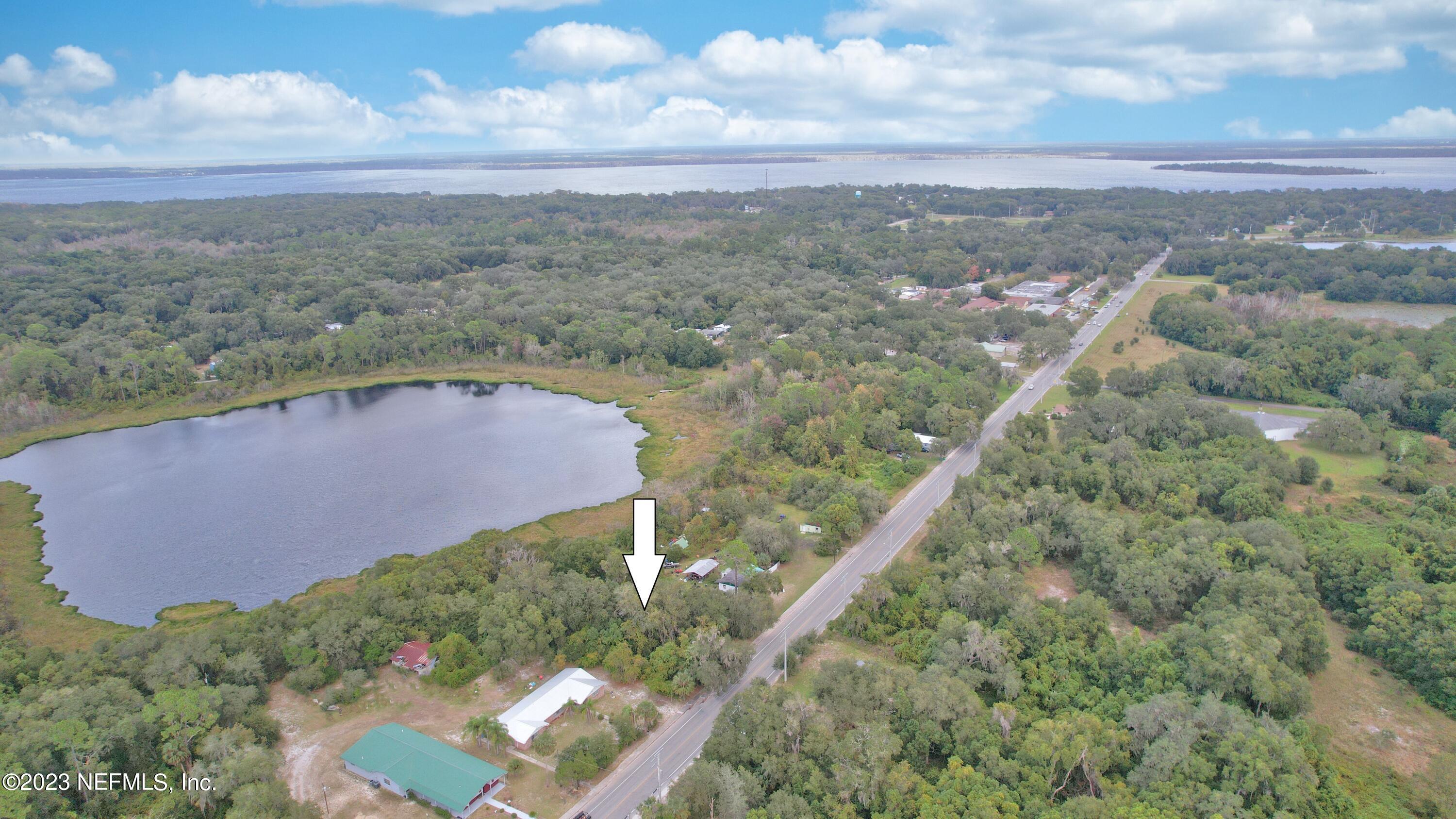 an aerial view of a house with a yard and lake view