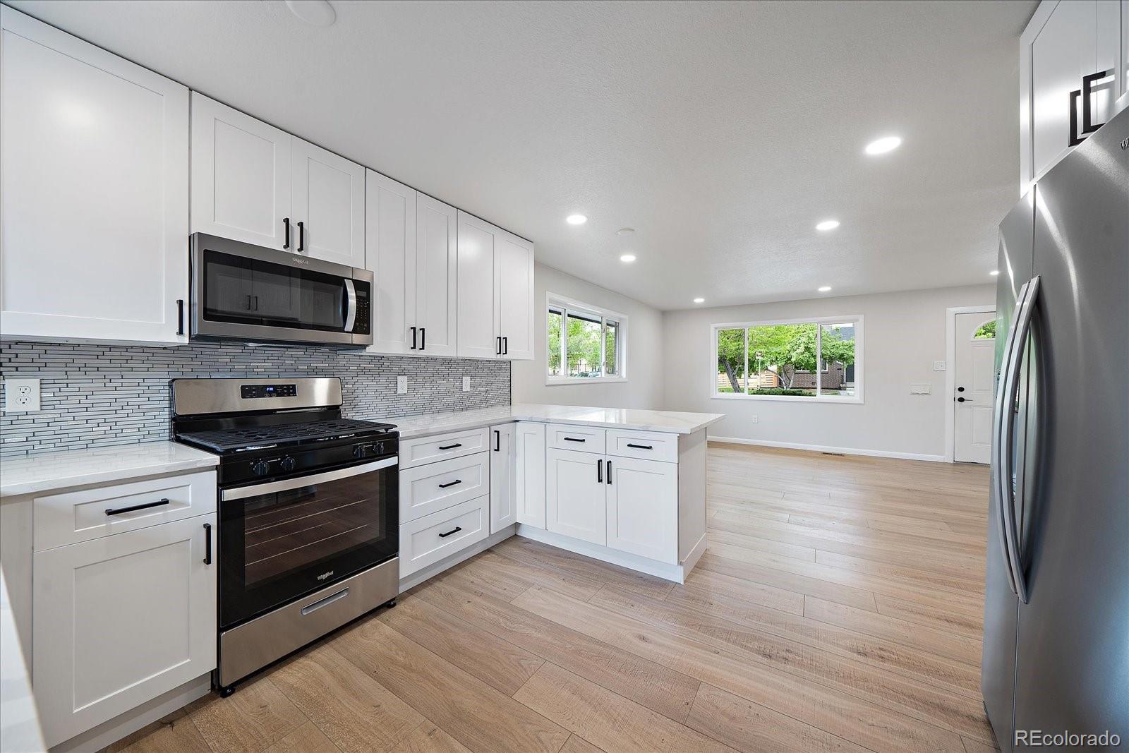 a kitchen with granite countertop a stove a sink and a microwave