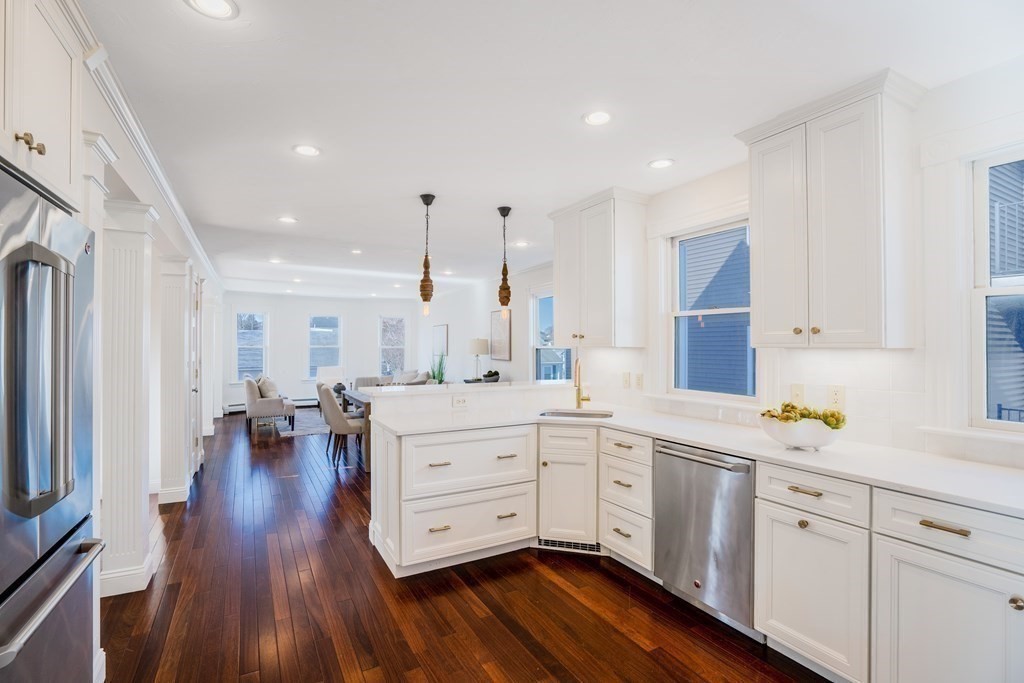 a kitchen with white cabinets sink and stainless steel appliances