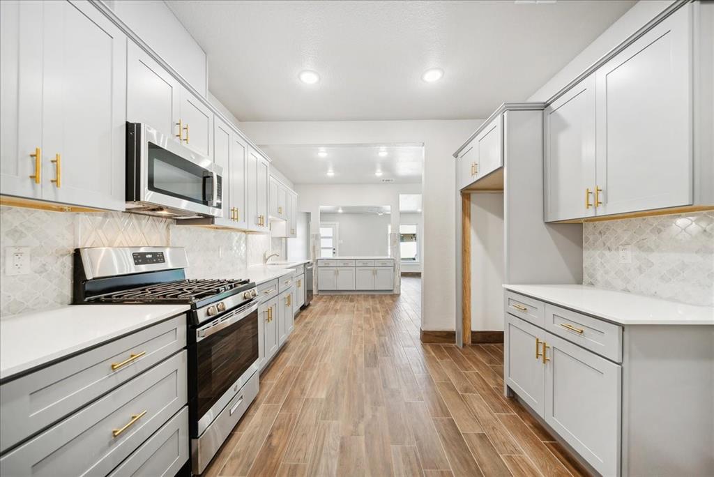 a kitchen with stainless steel appliances granite countertop a stove and a sink