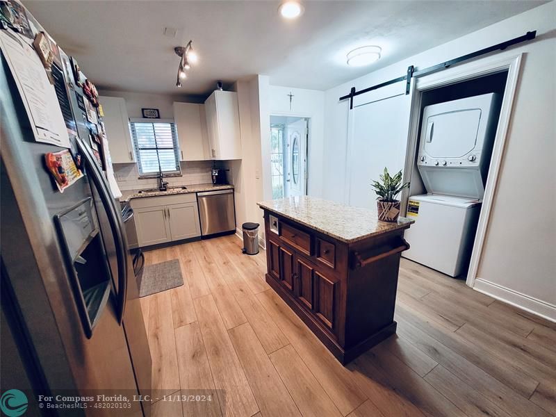 a kitchen with sink cabinets and wooden floor