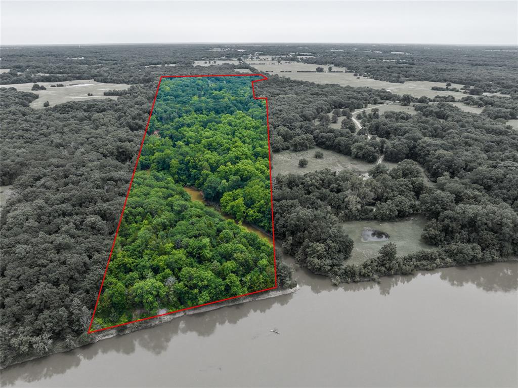 an aerial view of a houses with a yard and lake view