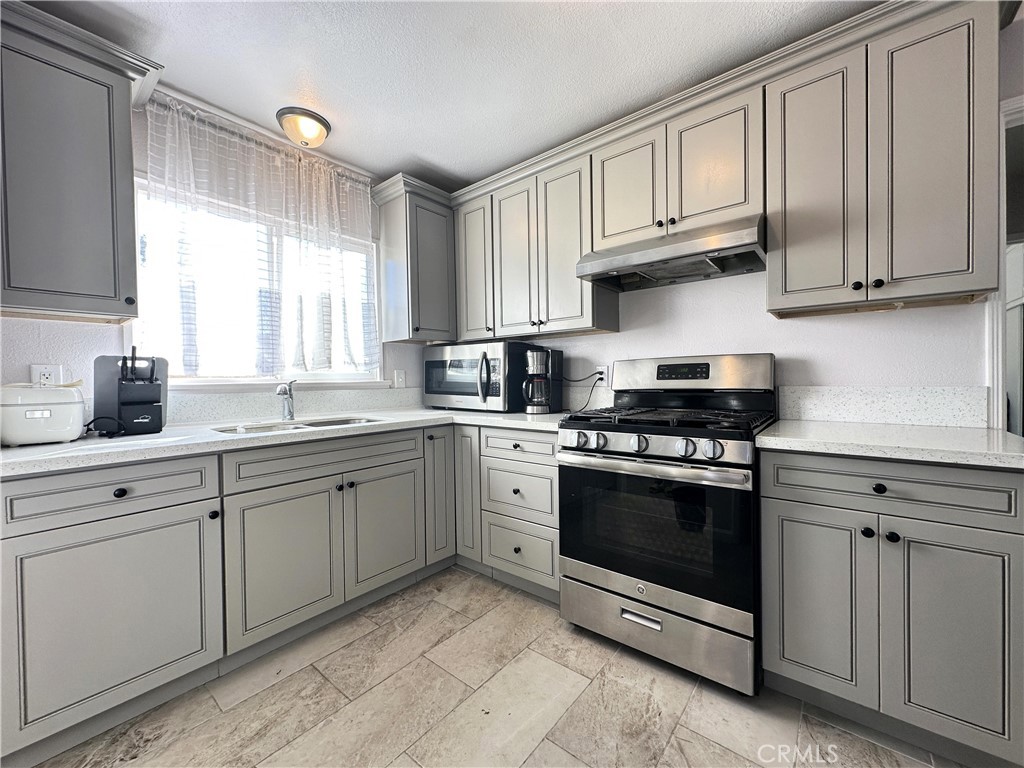 a kitchen with cabinets stainless steel appliances and a window