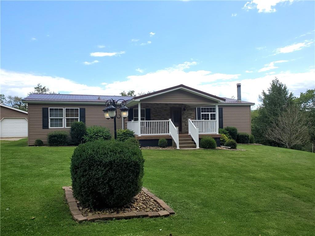 a front view of a house with a yard and trees