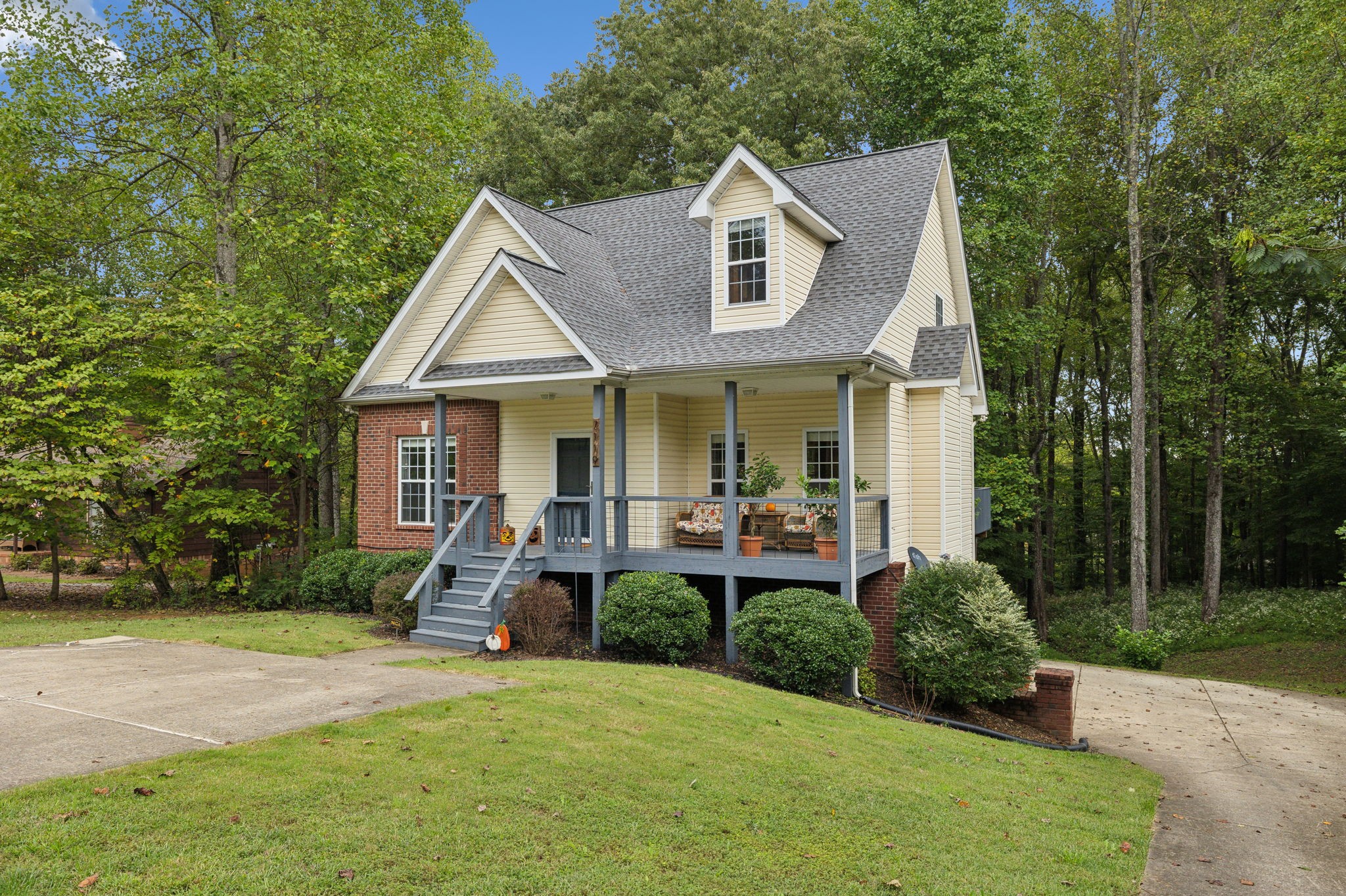 a front view of a house with porch and garden