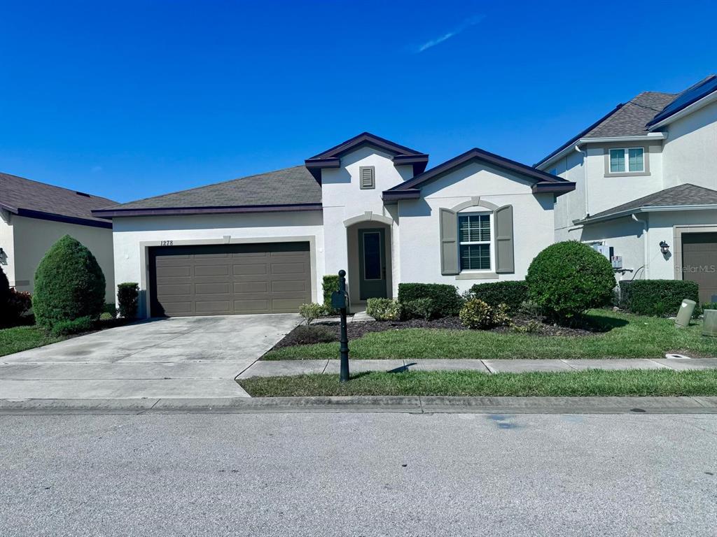 a front view of a house with a yard and garage