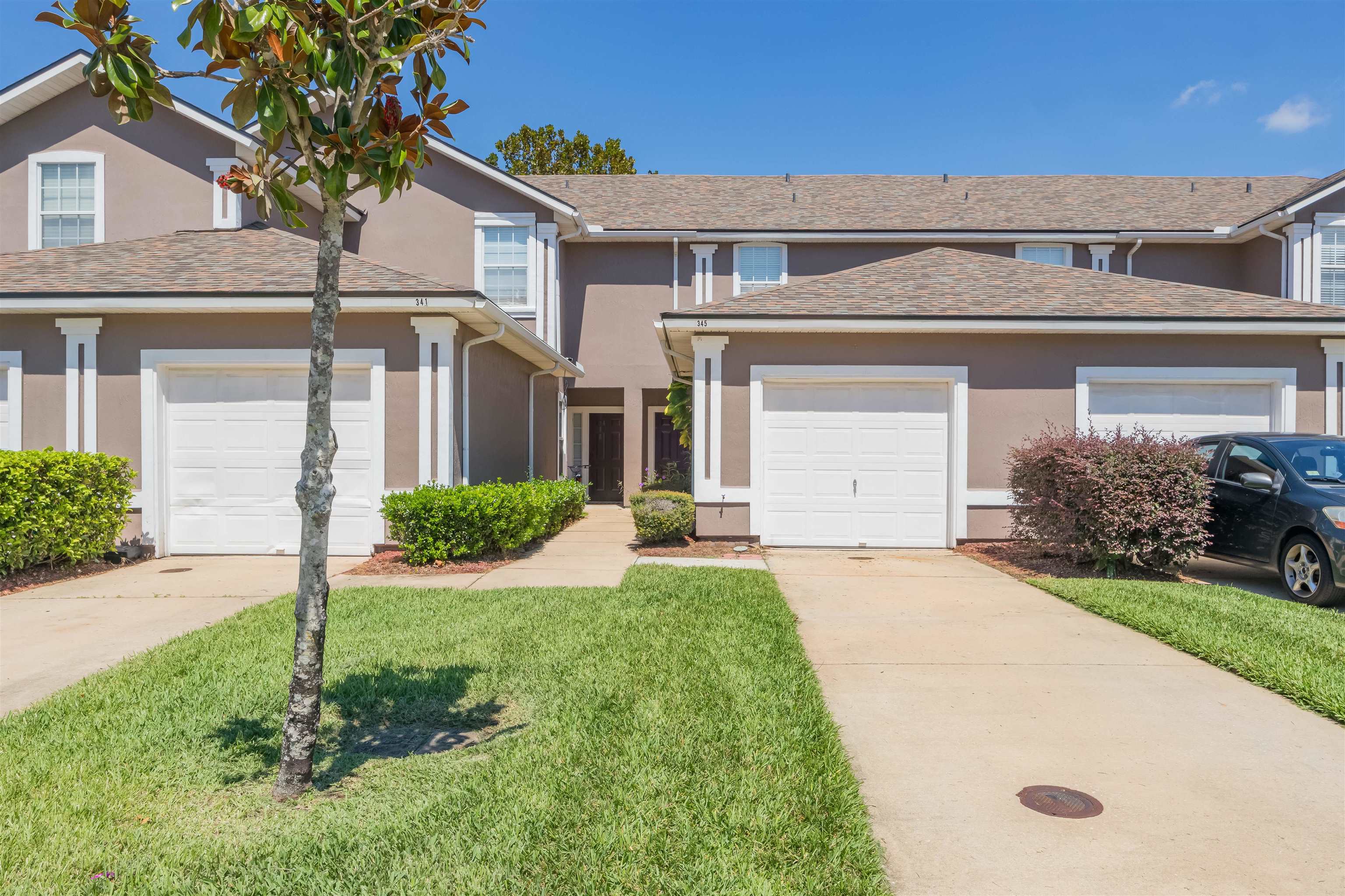 a front view of a house with a yard and garage