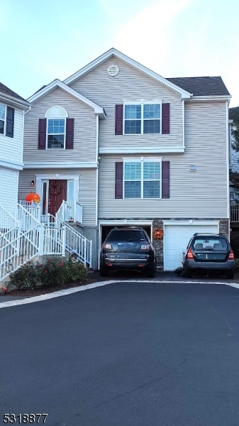 a couple of cars parked in front of a house