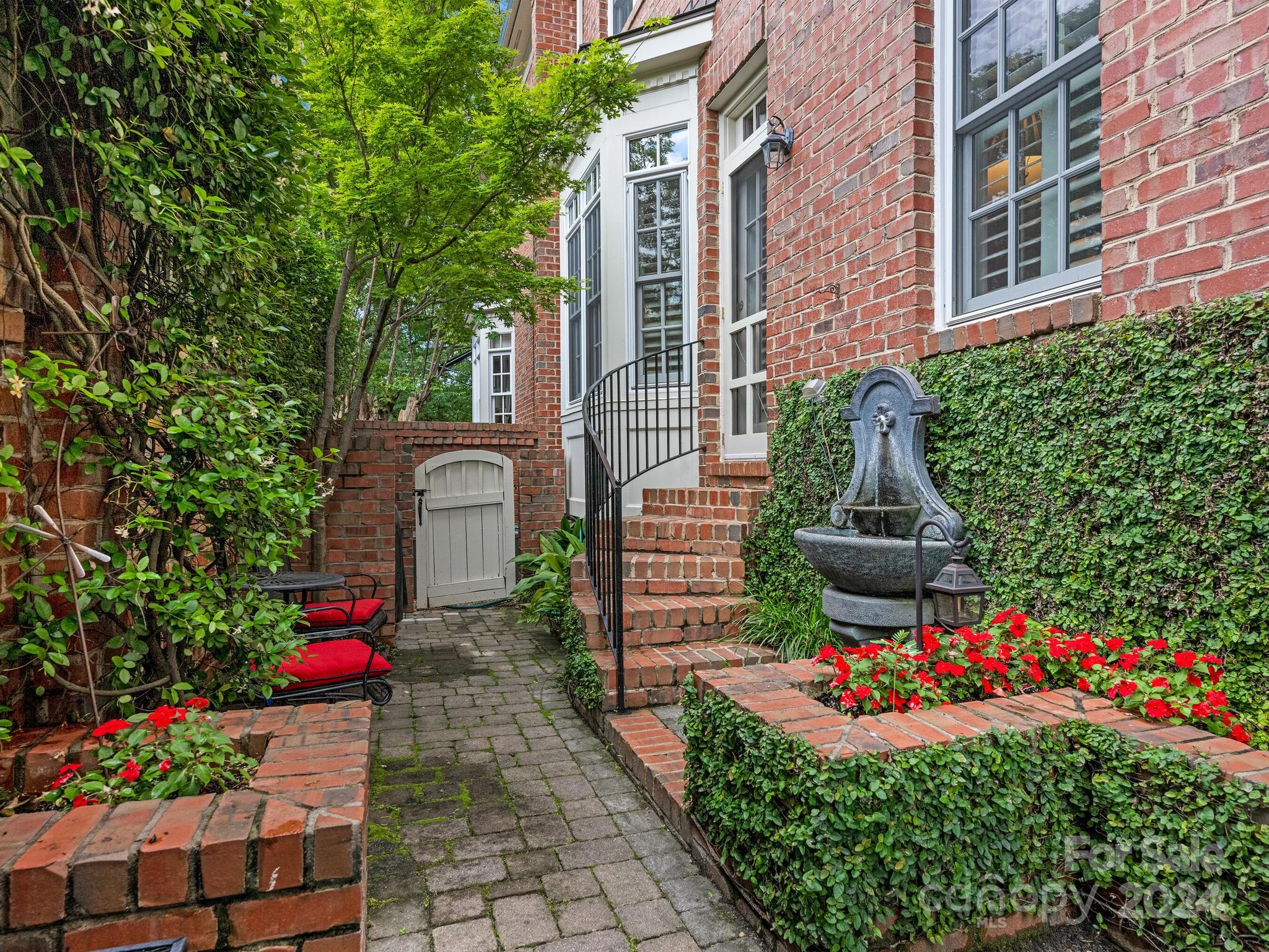 a front view of a house with a yard and fountain