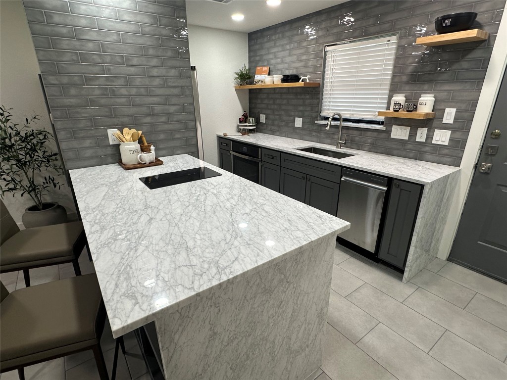 a kitchen with a sink a stove top oven and cabinetry