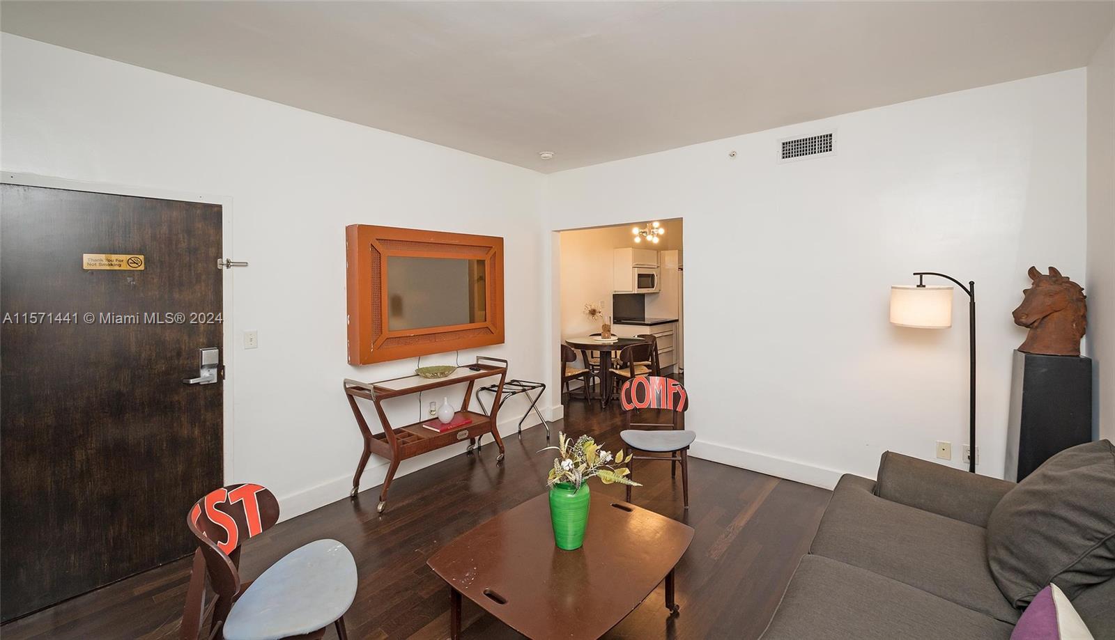 a living room with furniture a wooden floor and a mirror