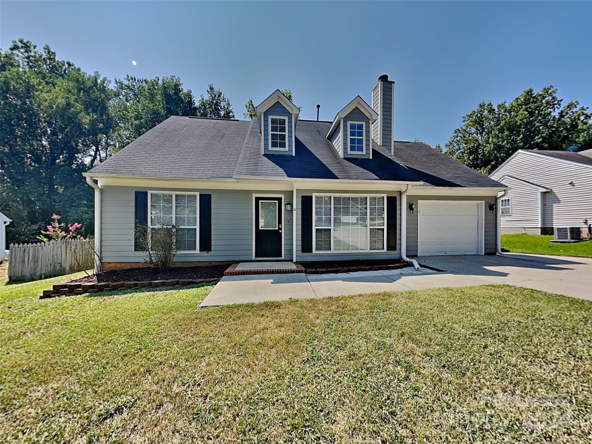 a front view of a house with a yard and outdoor seating