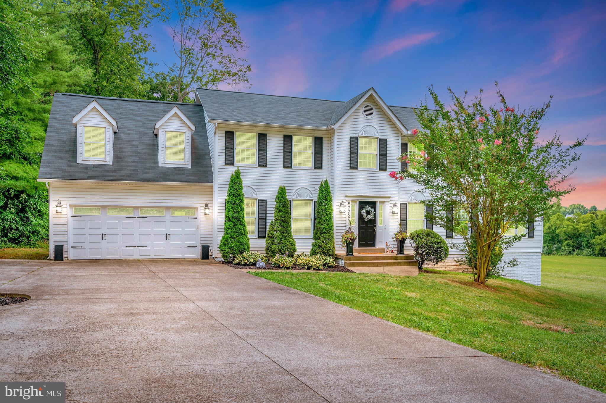 a front view of a house with a yard and trees