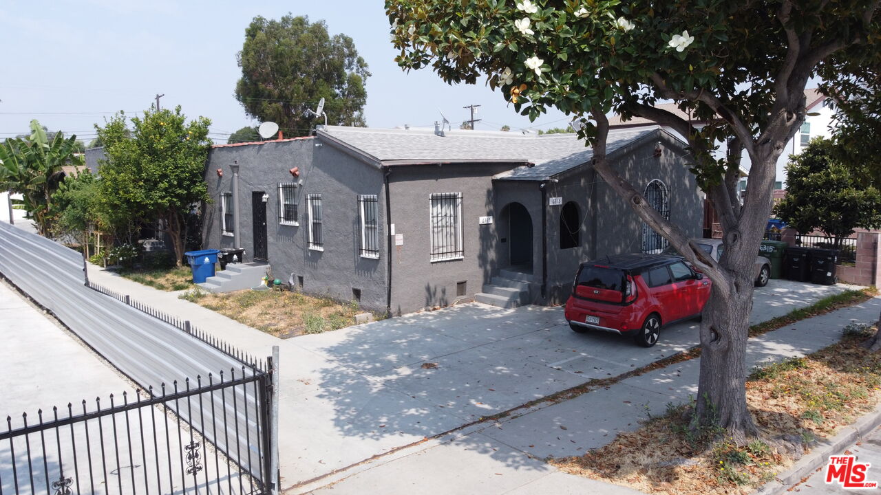 a front view of a house with yard outdoor seating and covered with trees