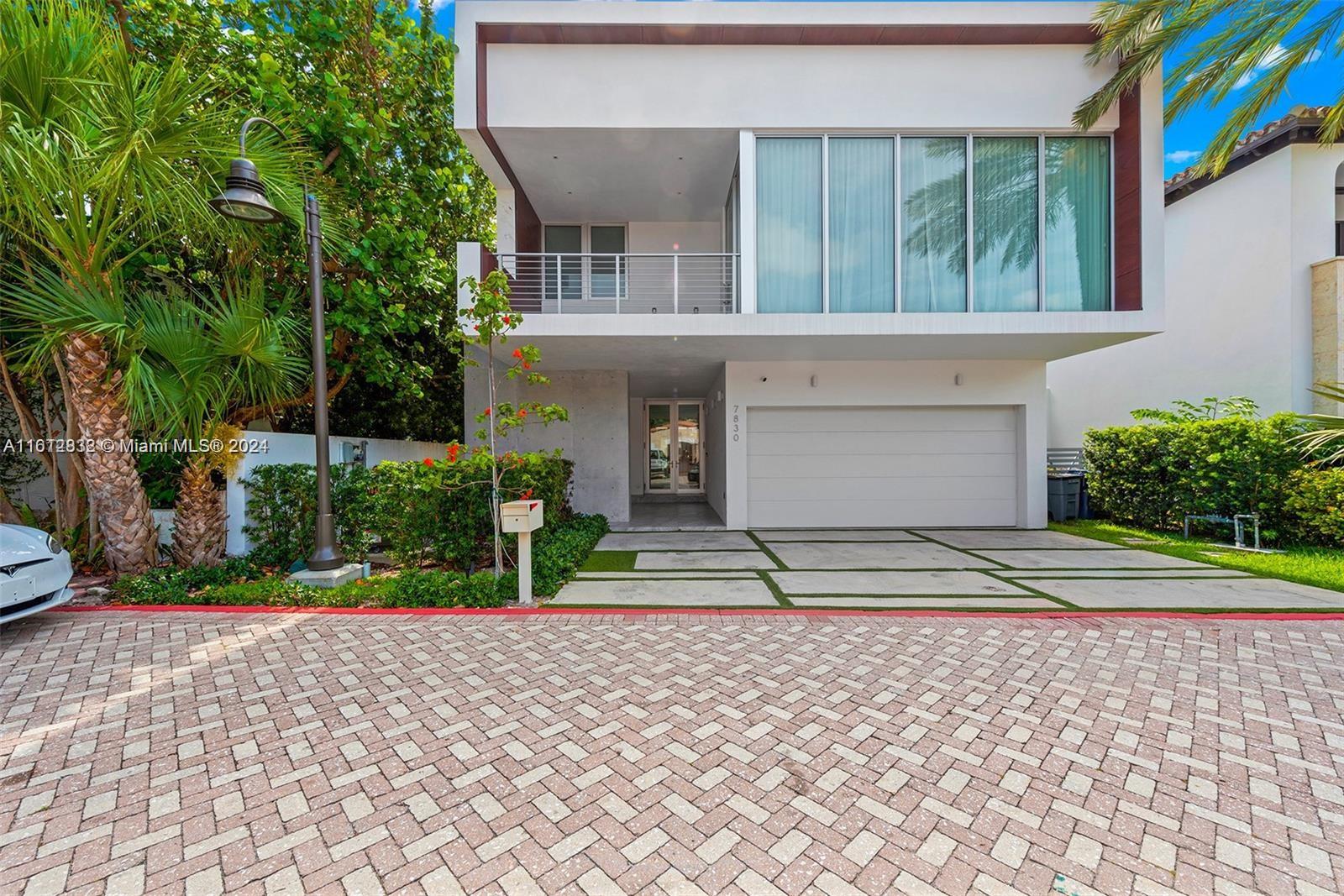 a front view of a house with a yard and potted plants