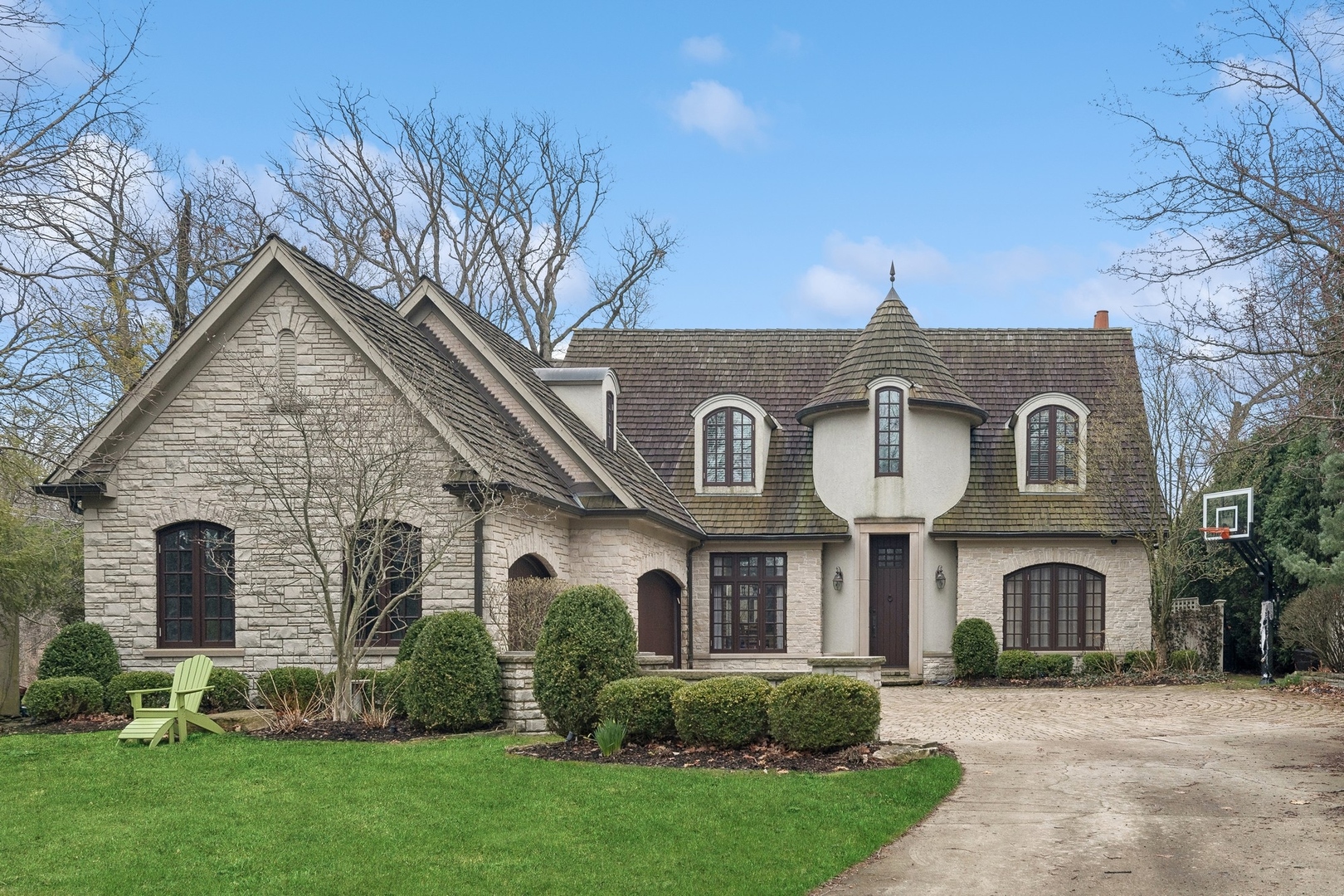 a view of a brick house with a clock on the side of a small yard