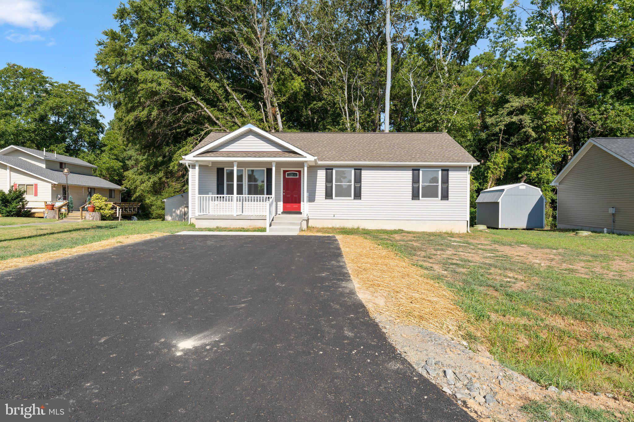 a front view of a house with a yard and trees