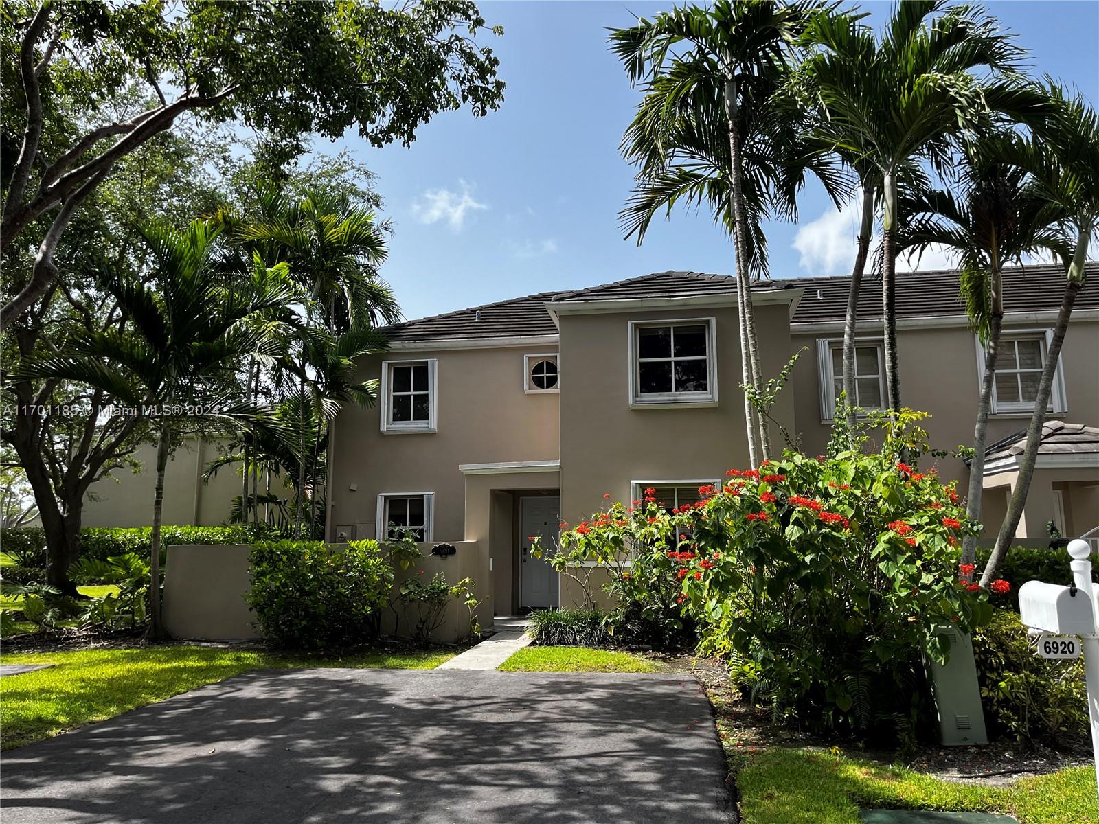 a front view of a house with a yard and a garden