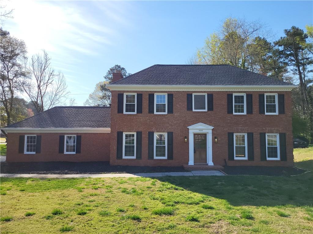 a front view of a house with yard and green space