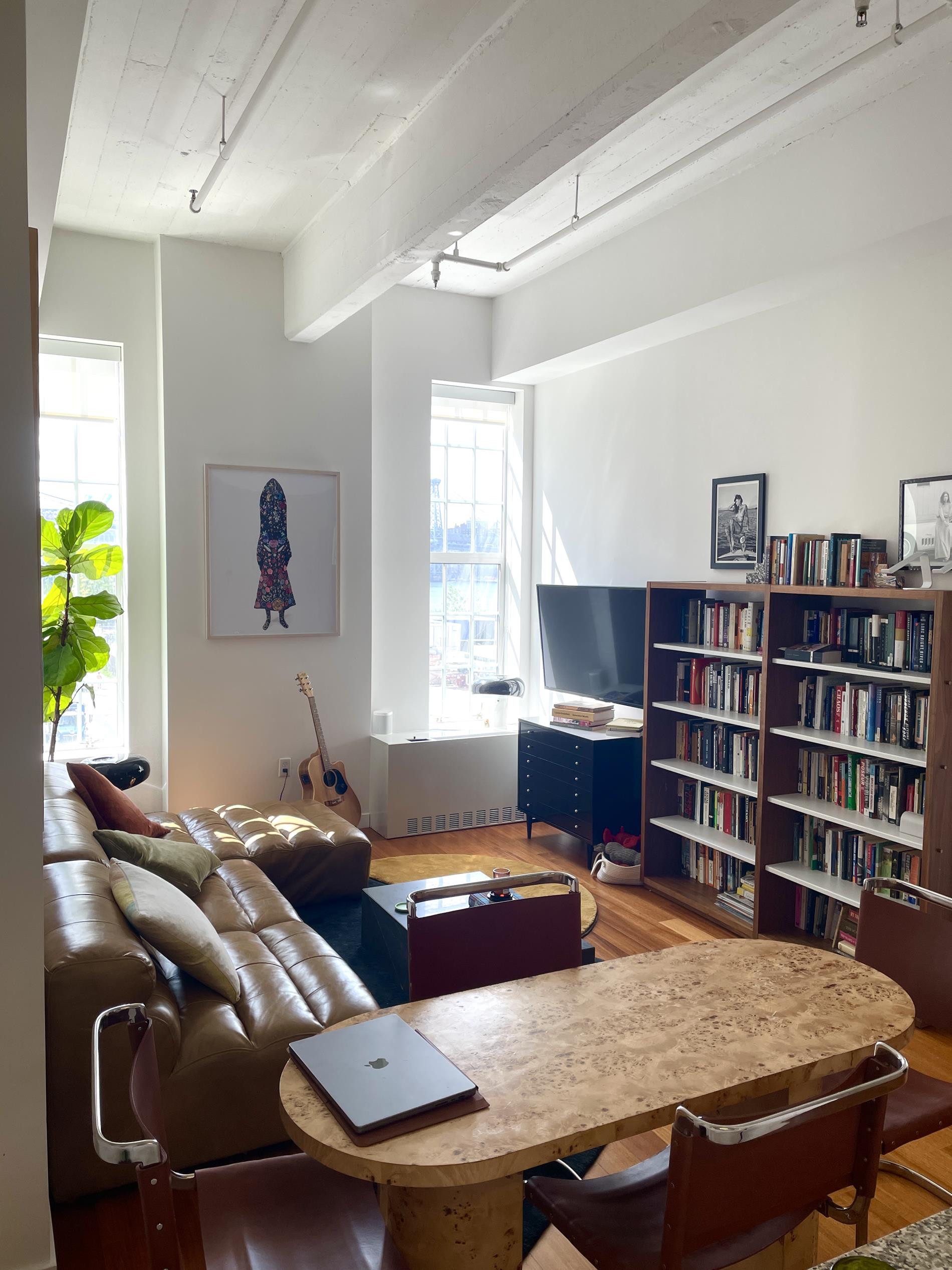 a living room with furniture a bookshelf and a window