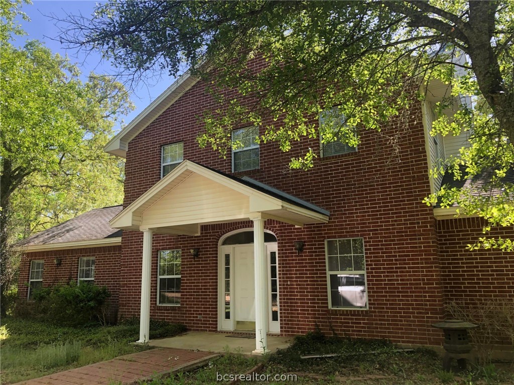 a front view of a house with a garden and plants